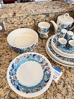 Overall view showing teapot, serving bowl, mugs, plates