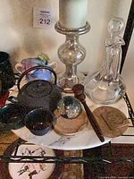 Overall view of teapot, cups, decanter, candlestick, paperweight, coasters, wooden tool