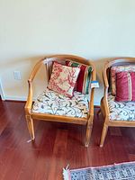 Both matching wooden barrel-back chairs with seat cushions and pillows