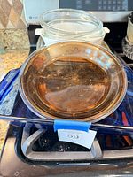 Stacked bakeware showing amber round casserole on blue baker, white casserole and clear dish