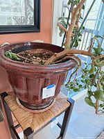 Side view of pot on stand showing glaze and ribbed design