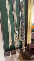 Group shot of necklaces hanging, showing variety of chains and beaded strands