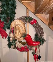 Grapevine wreath with hat and boot plus partial view of evergreen wreath