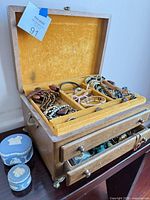 Open jewelry chest top tray with mixed necklaces and bracelets