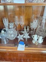 Overall view of all glassware, shakers and ornaments on cabinet shelf
