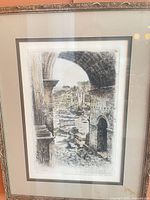 Full view of one framed etching showing Roman arch scene, frame detail visible