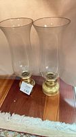 Two glass hurricane candle holders side by side