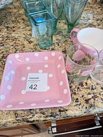 Square pink polka dot plate with glasses and mugs