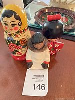 Front view of three cultural dolls with auction tag visible