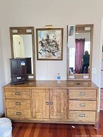 Front view of dresser with attached mirrors and closed drawers