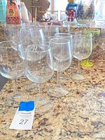 Group of clear wine glasses on counter showing monogram and quantity