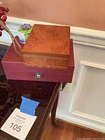 Stacked burl wood and burgundy boxes with small floral paper box