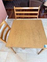 Top view of square solid oak table with two ladder-back pieces