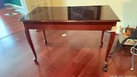 Full view of writing desk table showing cabriole legs and finish