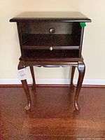 Front view of mahogany side table showing drawer and shelf