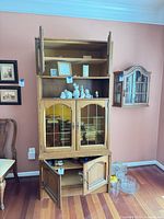 full view of two-piece oak hutch showing top, glass middle doors and base