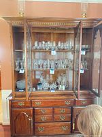 Full view of cabinet showing upper glass doors, glass shelves, lower drawers and doors