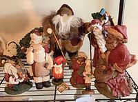 Shelf view showing multiple Santa figurines, establishes count and variety
