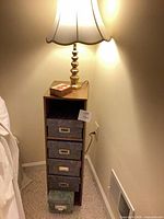 Cabinet with drawers and lamp illuminated on top