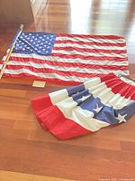 Flag laid flat, pole alongside, bunting folded