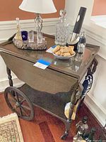 Overall view of dark brown wooden tea cart with glass top, accessories shown for scale only