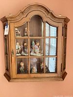 Front view showing arched top, glass pane door, shelves