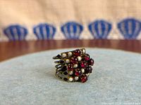 Front view showing tiered garnet and seed pearl cluster on multi bands