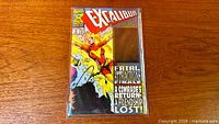 Full view of bagged Excalibur #71 comic showing cover art, title, signatures and hologram