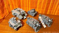 Group of five assembled plastic Vindicator Siege Tank miniatures on tabletop