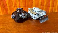 Front oblique view of both Warhammer 40k tanks on wooden surface