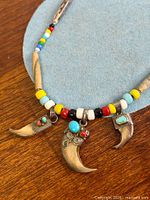 Full necklace showing beads, wood spacers, three claw pendants