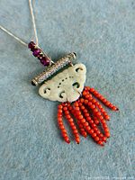 Front view of pendant showing jade plaque, coral bead fringe and gemstone tube bar on silver chain