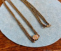 Full view of triple-strand gold filled slide chain necklace showing floral opal slider and clasp