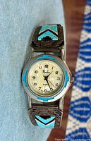 Front view showing dial and inlaid bracelet panels