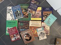 Overview of all fourteen antique reference books arranged on floor