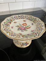 Full view of Dresden footed compote showing shape, lattice rim, and floral decoration
