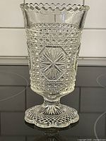 Full view of pressed glass spooner showing patterns and pedestal base