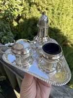 overview of tray with pepper shaker, mustard pot, salt cellar