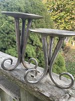 Both iron candle holders side by side on railing