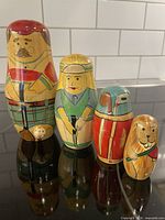 Four Midwest wooden nesting figures: male golfer, female golfer, golf bag, gopher