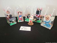 Group shot of all six figurines, five boxed and one resin on base