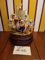 Front view showing Geppetto, Pinocchio, Blue Fairy, four mini globes, wood-tone base