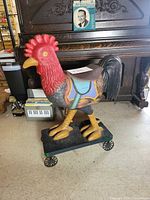 front three-quarter view of painted wooden rooster on wheeled base