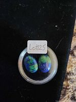 Two azurite–malachite cabochons in plastic display case