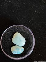 Two polished larimar stones front view in small dish