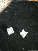Two quartz dodecahedron pendants on black velvet surface