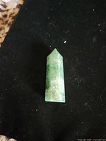Front view of green amazonite crystal point standing upright