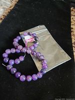 Coiled strand of purple faceted amethyst beads on bag