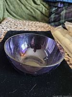 Side view of amethyst glass bowl on black surface