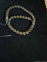 Strand of flat round black beads laid out